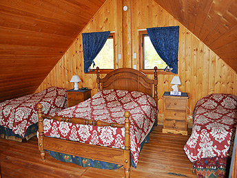 The loft bedroom in the large cabin has a Queen sized and two single beds.