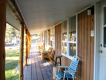 A deck with chairs spans the length of the motel and overlooks Nimpo Lake