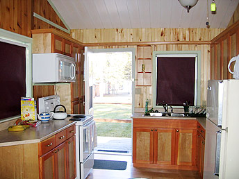 Large kitchen with microwave, fridge, stove.