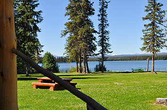 A lawn with picnic table in front of the motel leads down to the water.